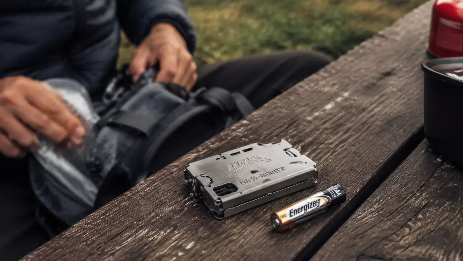 Close-up of BRS-3000T stove folded flat next to a AAA battery to show scale