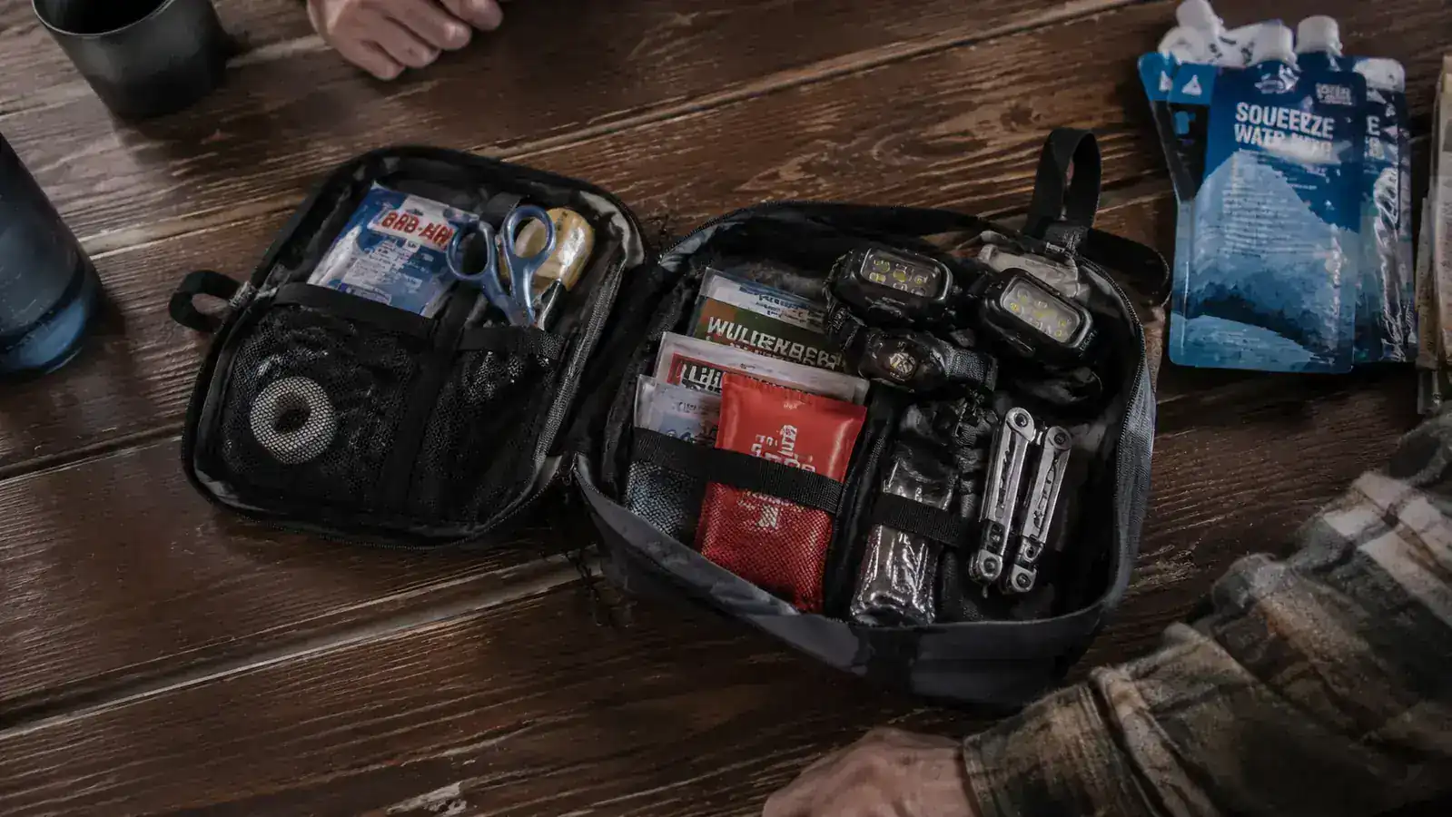 Emergency preparedness bag open on a table showing two LHKNL headlamps packed alongside other gear